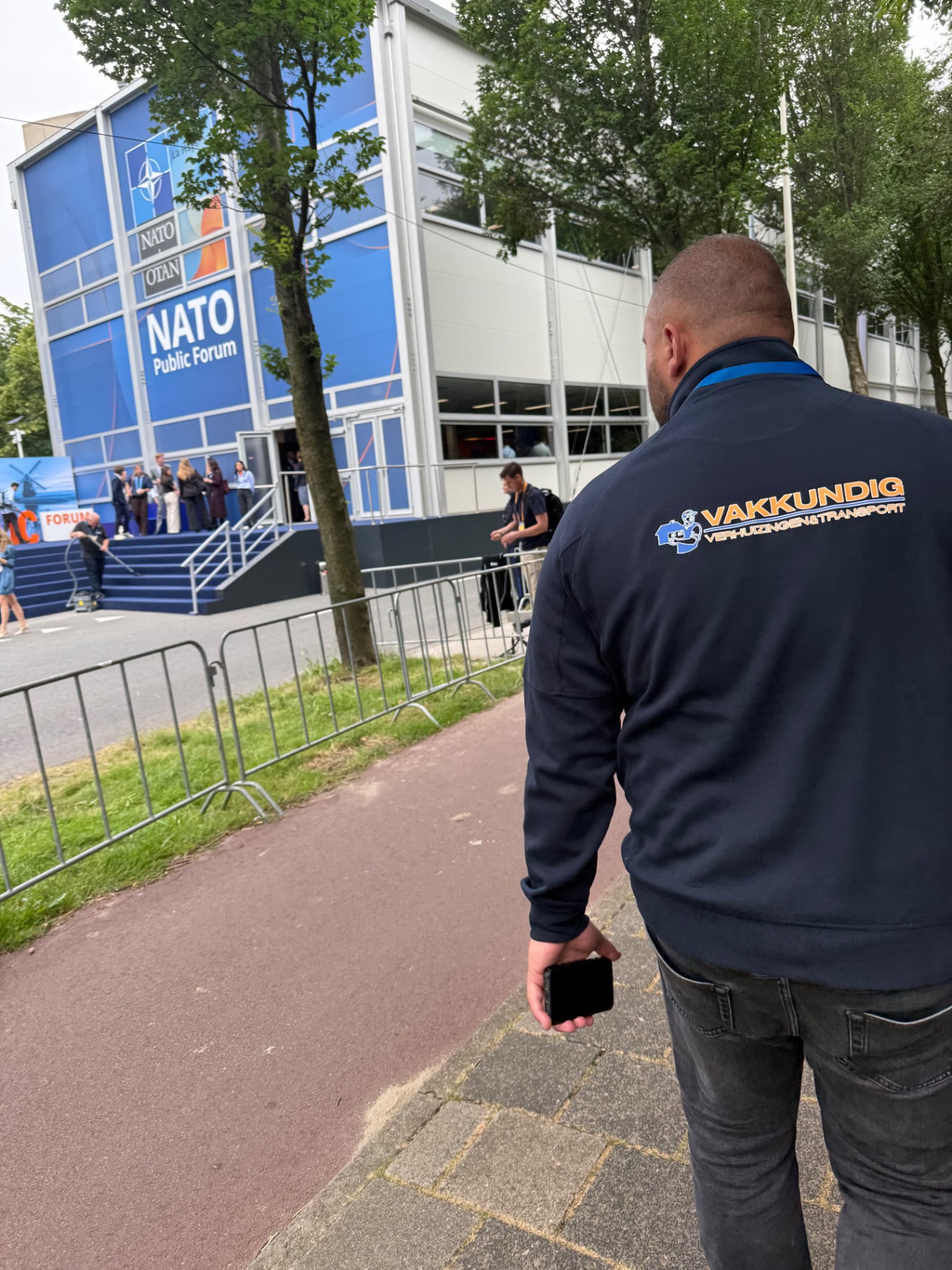 Medewerker van Vakkundig in bedrijfskleding bij de ingang van het NATO Public Forum