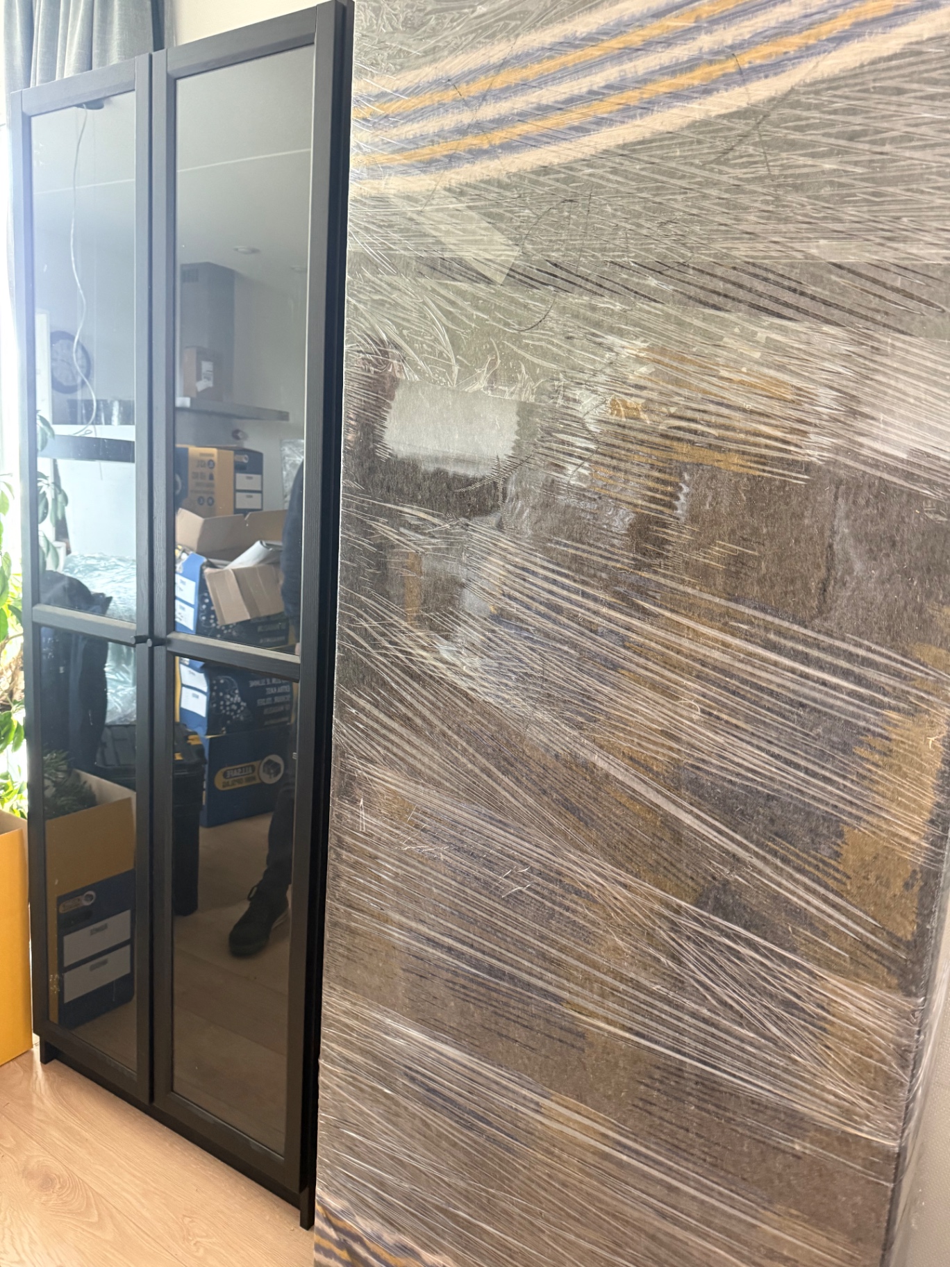 Kledingkast ingepakt met verhuisdekens en wikkelfolie tijdens een verhuizing