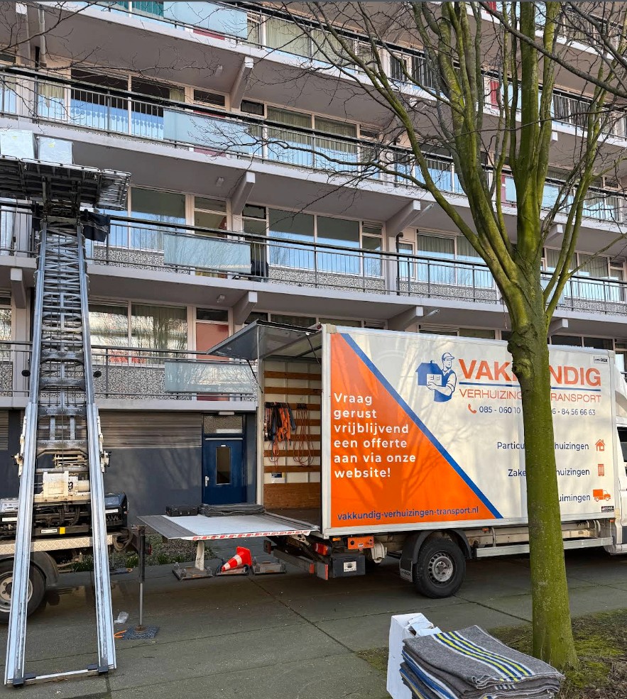 Verhuiswagen en verhuislift van Vakkundig bij een flat, met verhuisdekens klaar voor gebruik
