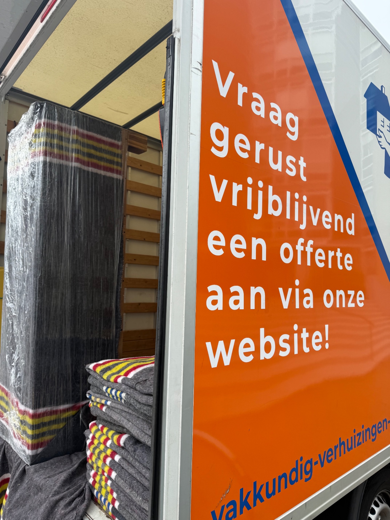 Ingeladen verhuiswagen met verhuisdekens en beschermde meubels