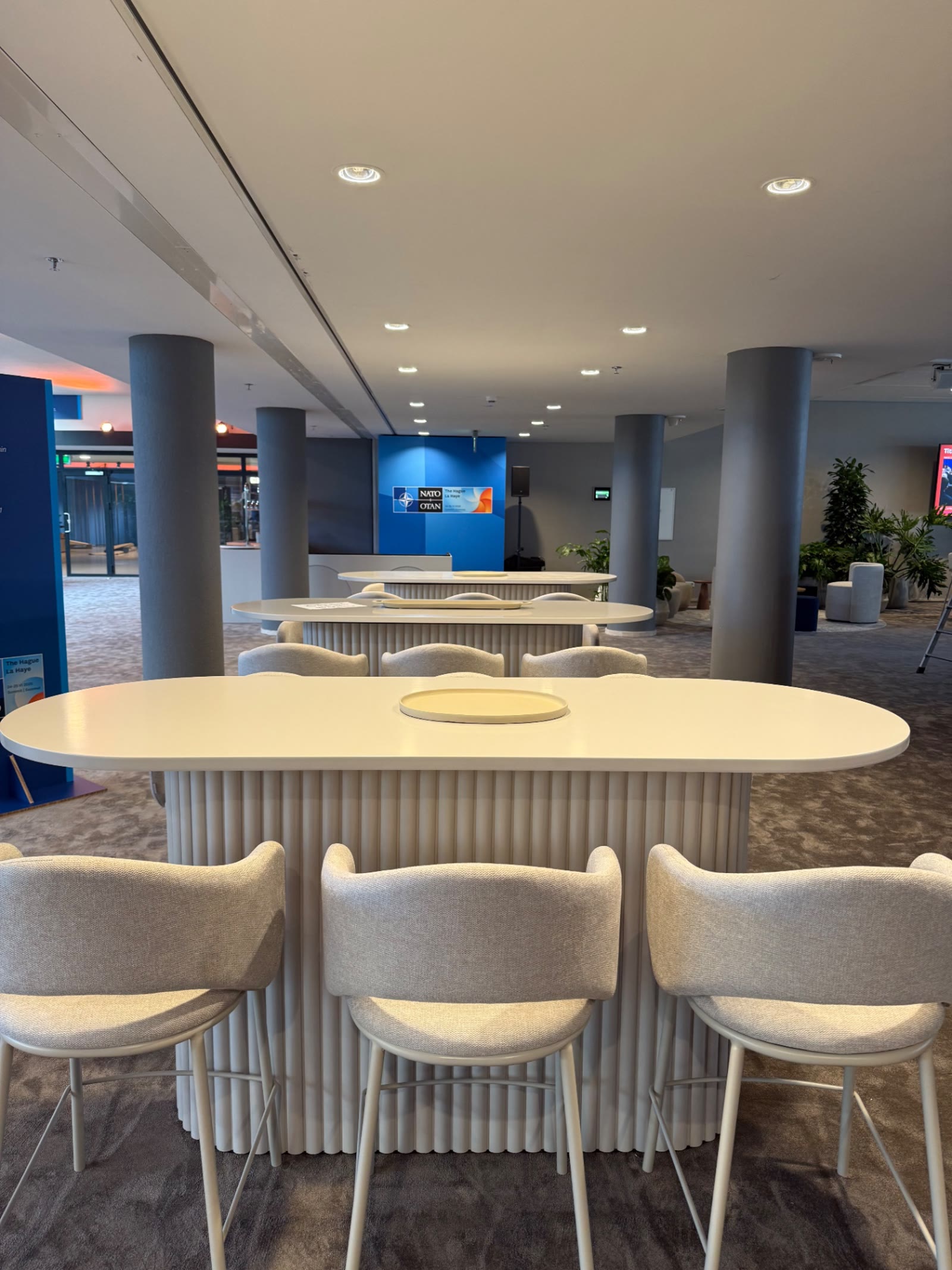 Sta-tafels en krukken opgesteld in een foyer tijdens een internationale top