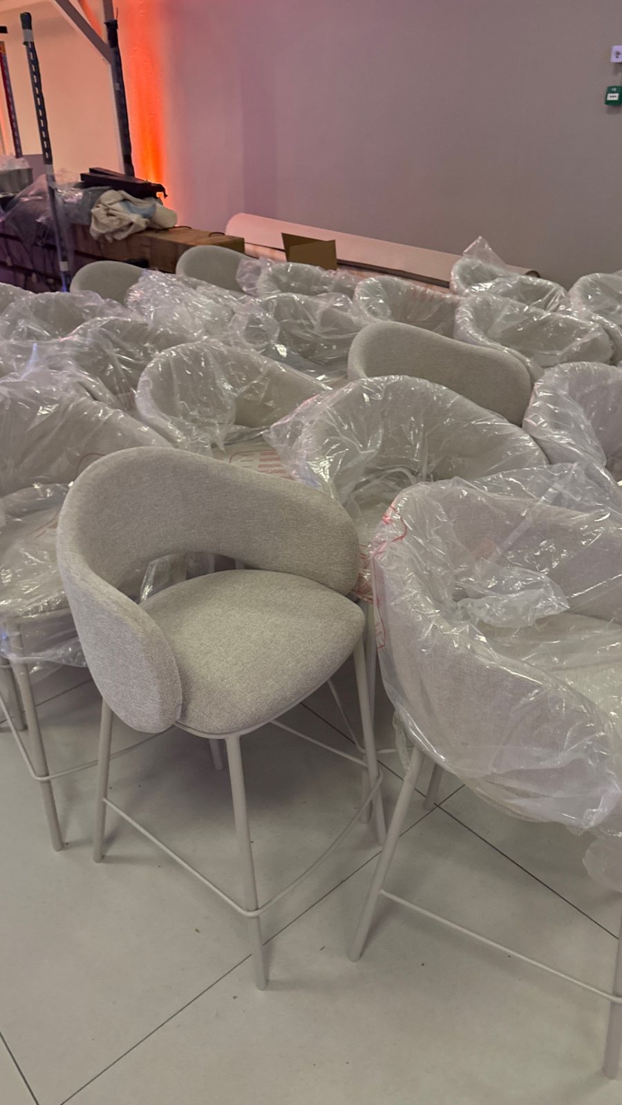 Tientallen ingepakte designstoelen klaar voor een evenement