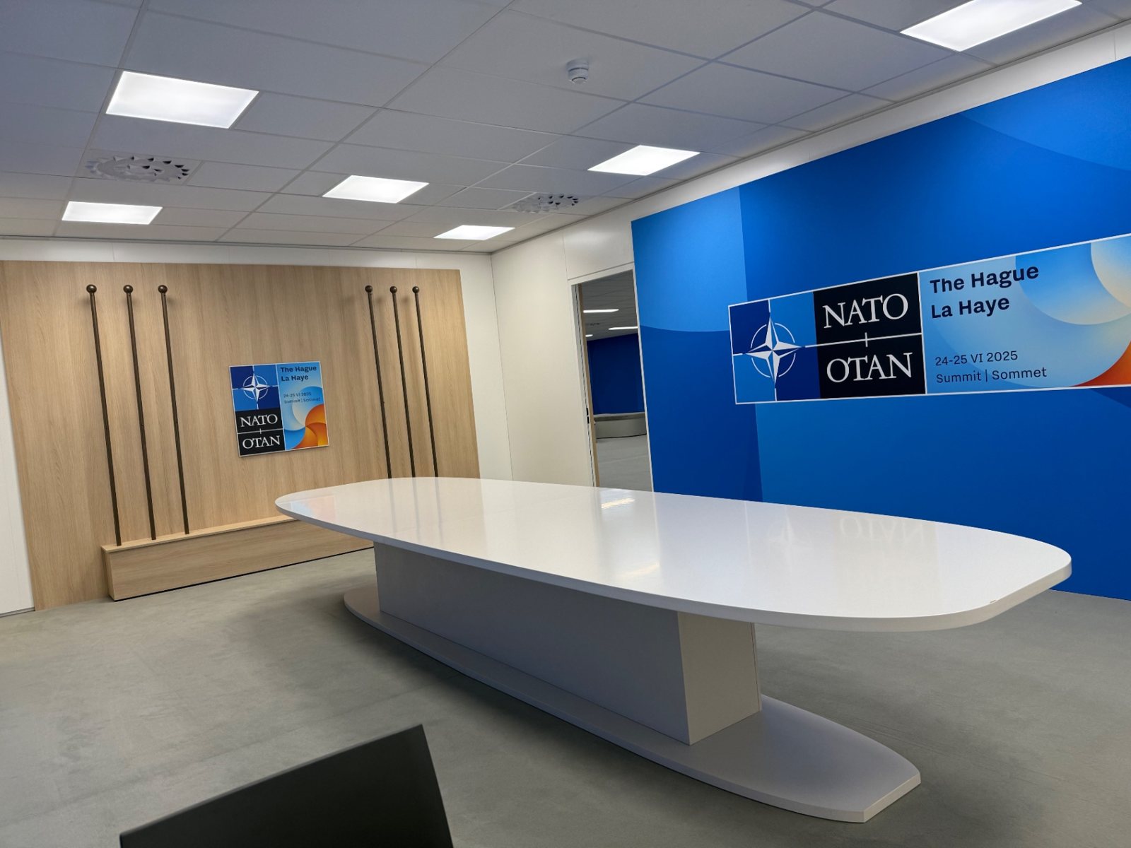 Grote vergadertafel geplaatst in een zaal van de NATO-top in Den Haag